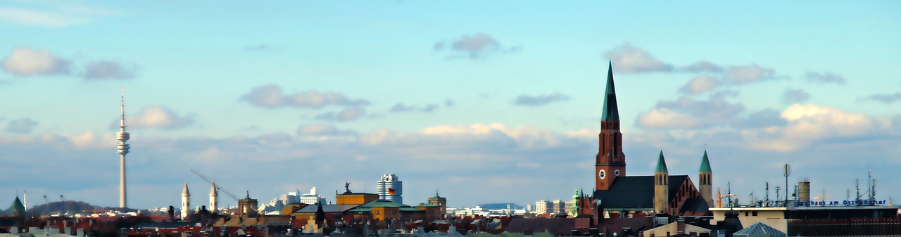 Panorama über die Dächer Münchens mit Olympiaturm links und Kirchtürmen im Norden der Stadt