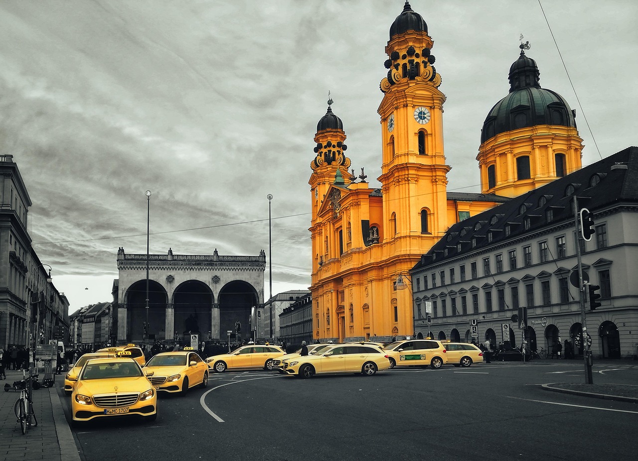 Wartendes Taxi am Odeonsplatz vor der gelben Fassade der Theatinerkirche